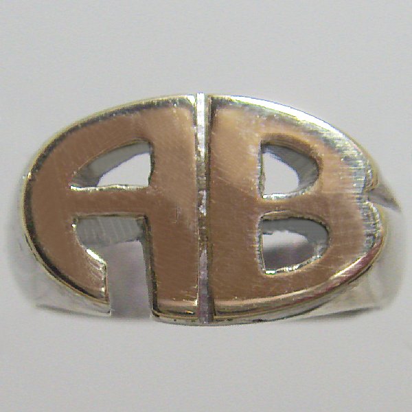 (r1056)Anillo tipo sello en plata y oro con iniciales caladas.